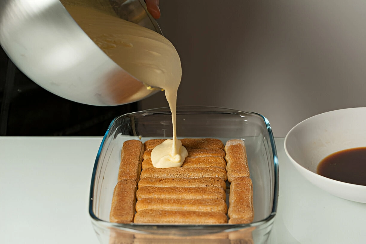 Préparation du tiramisu fait maison SOA NEM : montage avec crème mascarpone et biscuits